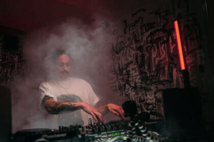 Stufferdnb drum and bass music production setup with audio equipment and sound waves on computer screen