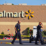 Police officer standing outside Kentucky Walmart store entrance providing security and safety for shoppers