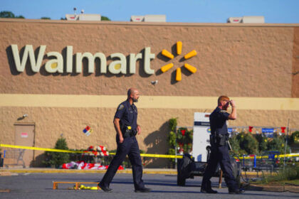Police officer standing outside Kentucky Walmart store entrance providing security and safety for shoppers