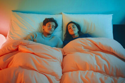 Couple sleeping peacefully with scandinavian sleep method benefits using two separate duvets on shared bed