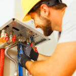Professional plumber performing water heater inspections with checklist and tools in residential basement