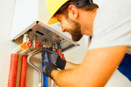 Professional plumber performing water heater inspections with checklist and tools in residential basement