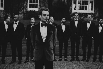 Elegant winter black tie outfit with velvet gown and tailored overcoat for formal cold weather events