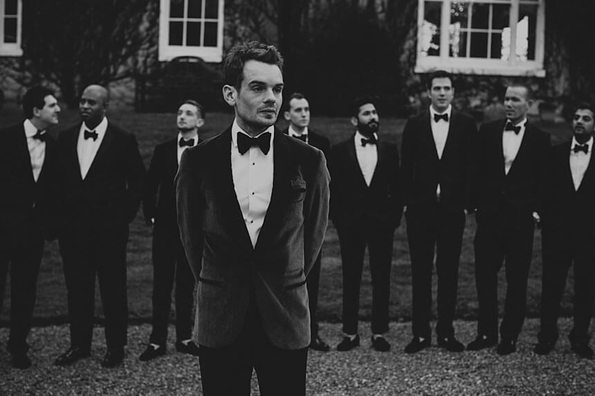 Elegant winter black tie outfit with velvet gown and tailored overcoat for formal cold weather events