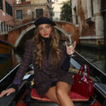 Carrington Durham net worth lifestyle photo showing Instagram influencer in Venice gondola wearing designer outfit
