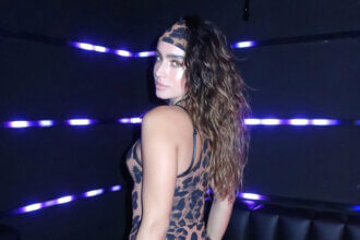 Sommer Ray net worth success shown through her DJ performance at nightclub with blue lighting
