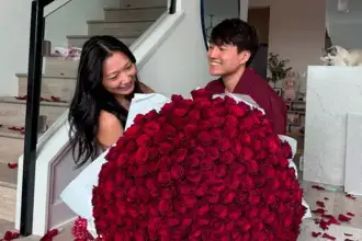Andy and Michelle holding large bouquet of red roses celebrating their net worth success as social media couple