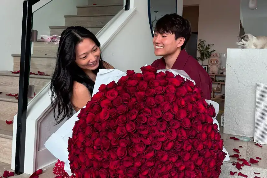 Andy and Michelle holding large bouquet of red roses celebrating their net worth success as social media couple