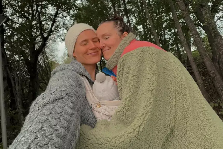 Julie and Camilla Lorentzen smiling together outdoors with their baby, Norwegian influencer couple discussing net worth